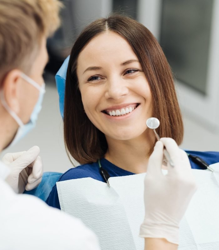 Male Professional Dentist With Gloves And Mask And Discuss What The Treatment Will Look Like Of The Patient's Teeth. Discussion Of The Treatment Plan And Healthy Smile